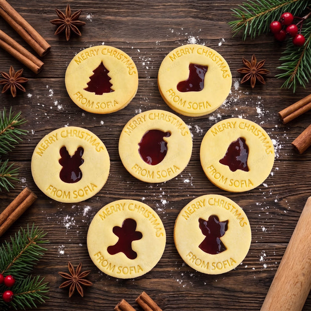 Biscotti linzer natalizi con marmellata, sagome festive e scritta personalizzata “Merry Christmas from Sofia”.
