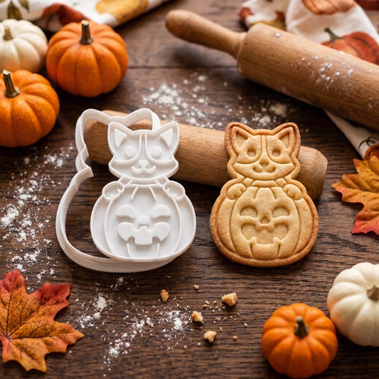 Tagliabiscotti e timbro cane con zucca Halloween accanto a un biscotto con lo stesso disegno.