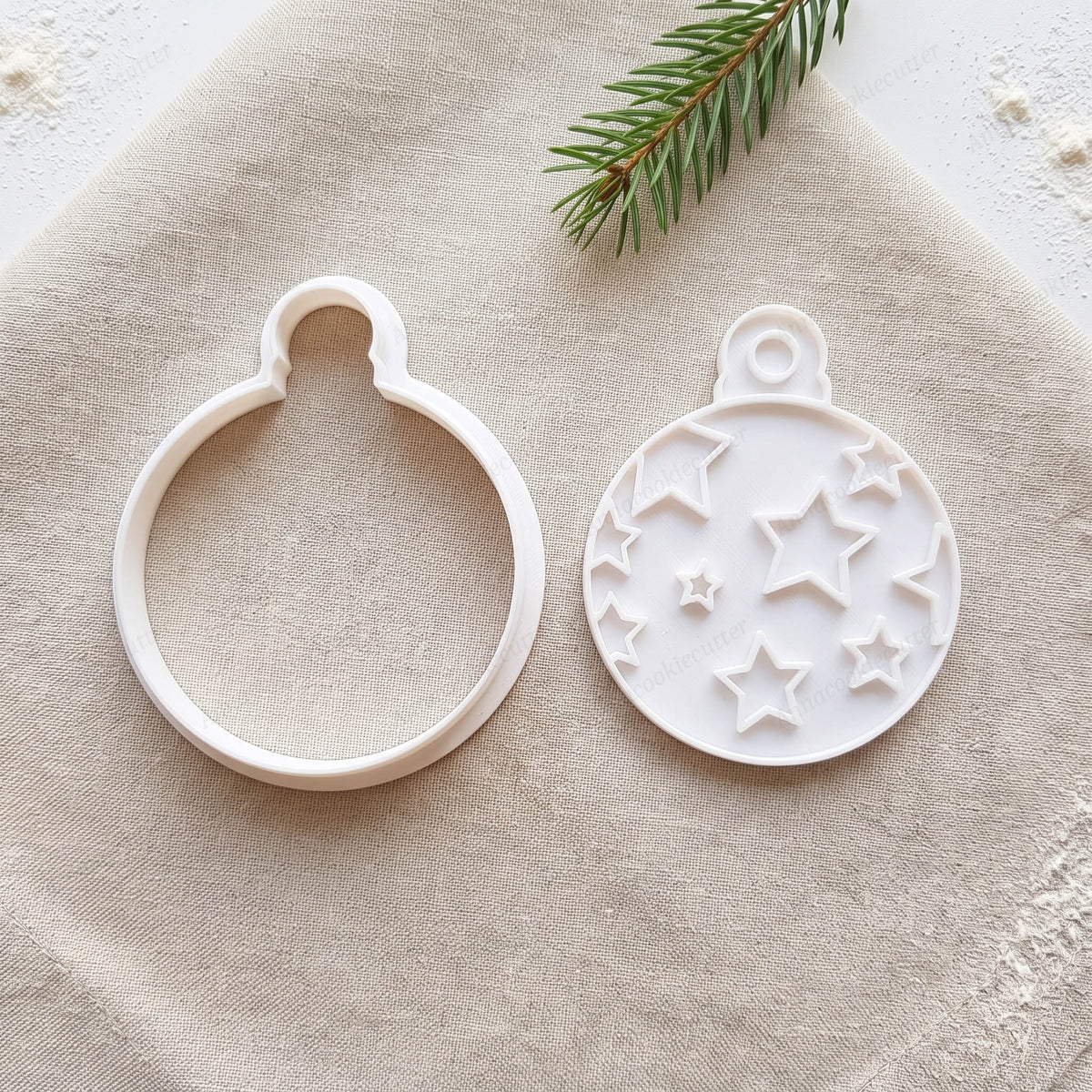 Set con tagliabiscotti e timbro separati a forma di pallina di Natale con motivo a stelle.