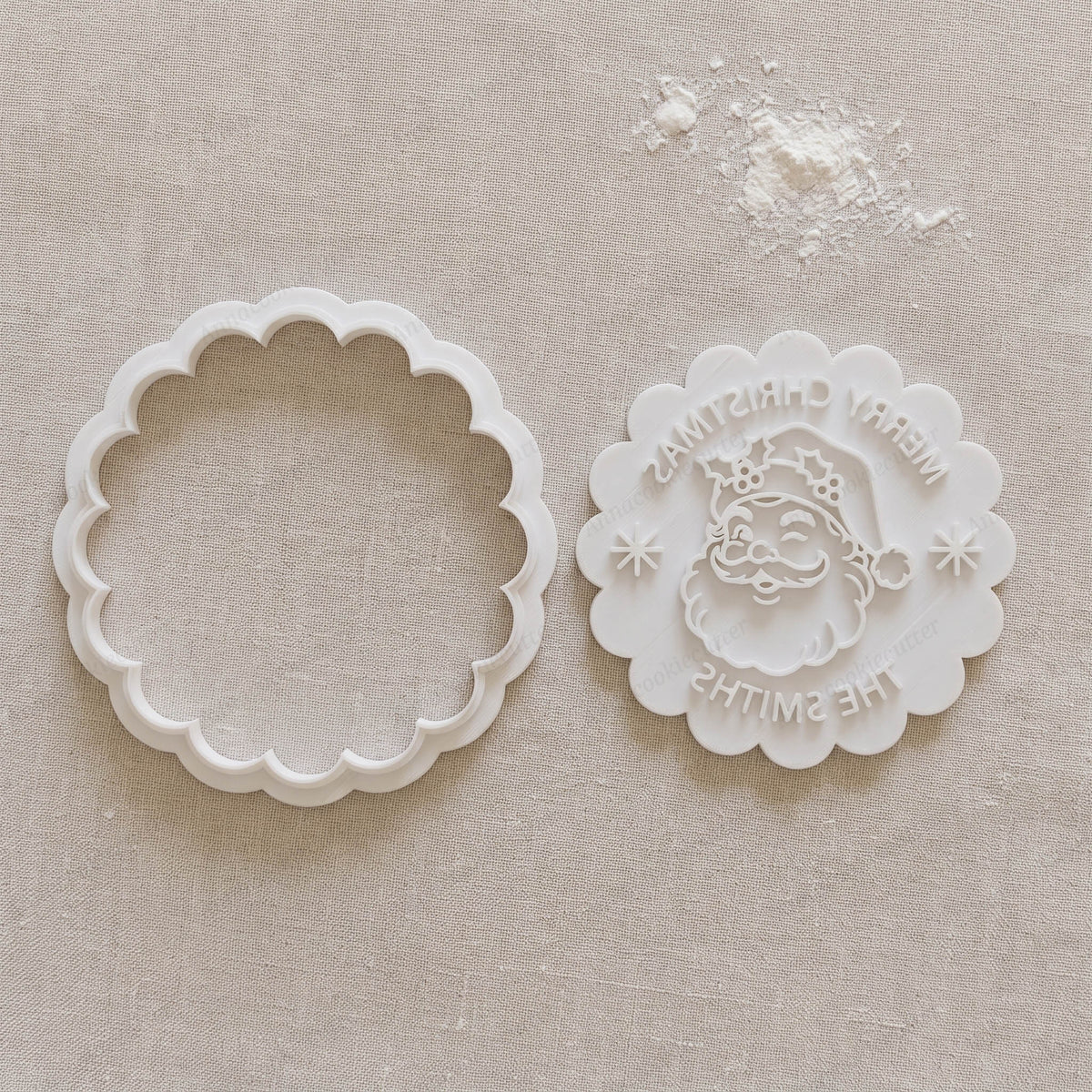 Set bianco con tagliabiscotti festonato e timbro separato, con Babbo Natale, agrifoglio, fiocchi di neve e nome personalizzato.